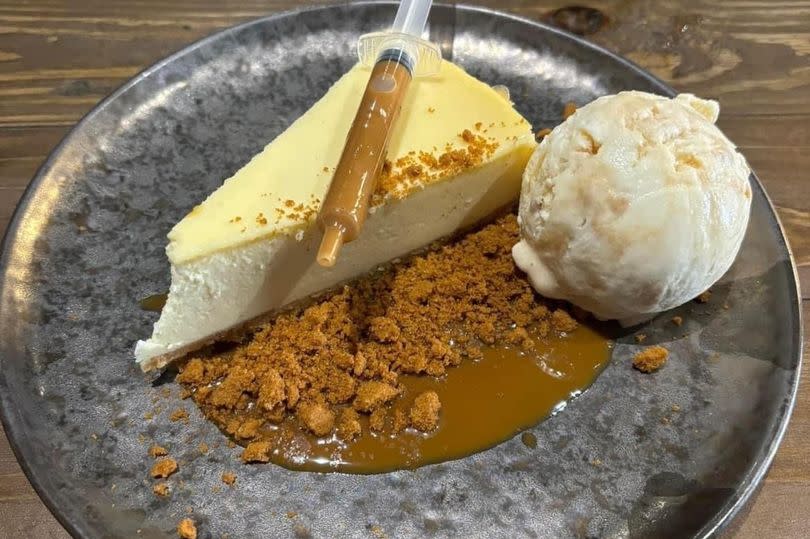 Cheesecake and biscoff with ice cream on a wooden table