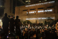 FILE - In this Saturday, July 25, 2020, file photo, the words "I can't breathe" are flashed on a wall during a Black Lives Matter protest in Portland, Ore. State legislatures across the U.S. are pushing an array of policing reforms after the demonstrations related to the death of George Floyd last spring, from banning chokeholds to making it easier to hold officers legally accountable for their actions. (AP Photo/Marcio Jose Sanchez, File)