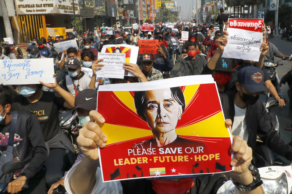 A protester holds an image of deposed Myanmar leader Aung San Suu Kyi as fellow protesters march around Mandalay, Myanmar on Monday, Feb. 8, 2021. A protest against Myanmar's one-week-old military government swelled rapidly Monday morning as opposition to the coup grew increasingly bold. (AP Photo)