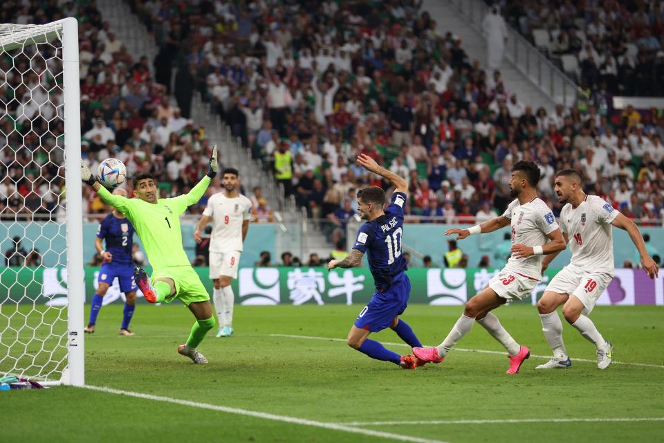 Christian Pulisic of the United States scores the team's first goal past Alireza Beiranvand of IR Iran during the FIFA World Cup Qatar 2022 Group B match between IR Iran and USA at Al Thumama Stadium on Nov. 29, 2022, in Doha, Qatar.