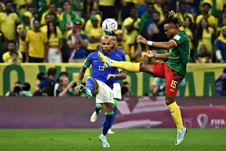 Brazil's defender #13 Dani Alves (L) fights for the ball with Cameroon's midfielder #15 Pierre Kunde (R) during the Qatar 2022 World Cup Group G football match between Cameroon and Brazil at the Lusail Stadium in Lusail, north of Doha on December 2, 2022. (Photo by Jewel SAMAD / AFP)