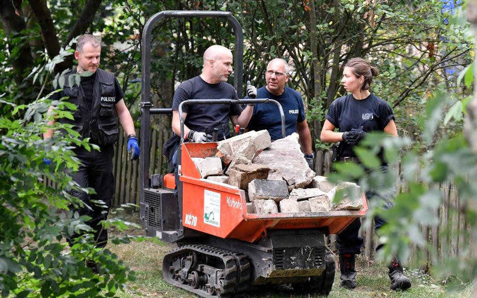 Police with a small digger - AP Photo/Martin Meissner