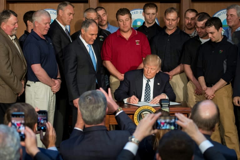 Surrounded by miners from Rosebud Mining, US President Donald Trump (C) signs the Energy Independence Executive Order at the Environmental Protection Agency (EPA) Headquarters in Washington, DC, on March 28, 2017