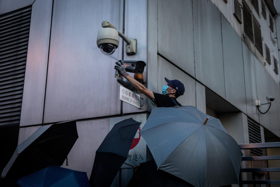 A protester covers a camera outside a government office in Hong Kong in July | Chris McGrath—Getty Images