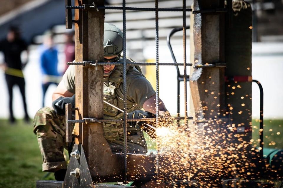 A US Army staff sergeant cuts through an obstacle designed to simulate a steel-reinforced window