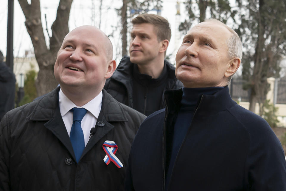 Russian President Vladimir Putin, right, and Governor of Sevastopol Mikhail Razvozhayev visit the Children's Art and Aesthetic center, part of Chersonesos Taurica historical and archeological park in Sevastopol, Crimea, Saturday, March 18, 2023. Putin has traveled to Crimea to mark the ninth anniversary of the Black Sea peninsula's annexation from Ukraine. (Sputnik, Kremlin Press Service Pool Photo via AP)