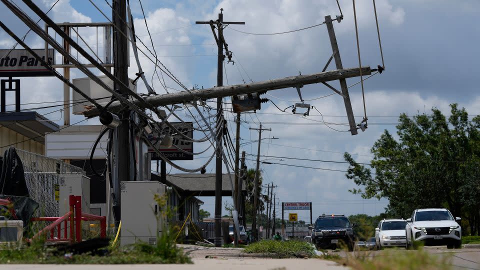 Traffic is directed around a downed power line in Houston, Texas, on Tuesday. - Eric Gay/AP