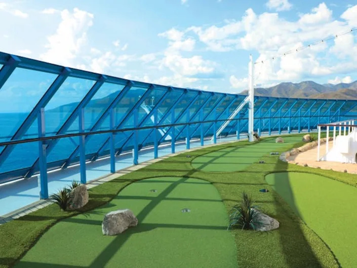 A putting green on the side of the ship with views of the ocean.
