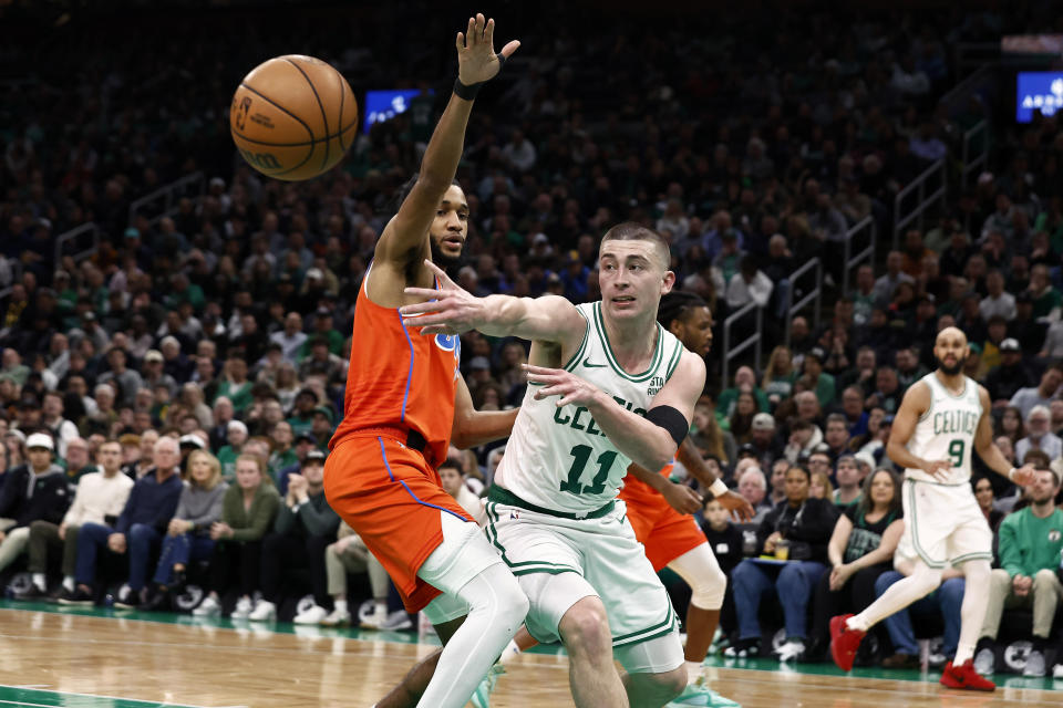 Boston Celtics' Payton Pritchard passes the ball past Oklahoma City Thunder's Isaiah Joe during the first half of an NBA basketball game Wednesday, April 3, 2024, in Boston. (AP Photo/Winslow Townson)