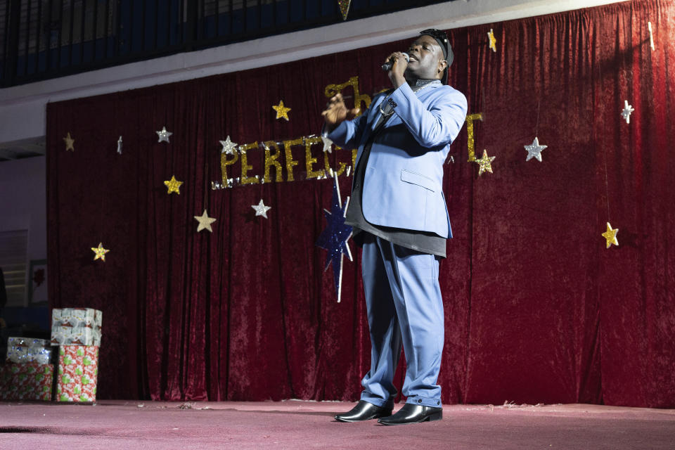 Bishop Lawrence Rolle performs at a Christmas concert at Mt. Carmel Preparatory Academy in Nassau, Bahamas on Thursday, Dec. 8, 2022. Rolle raises money through his Afro-Caribbean gospel music performances, which he uses to feed 2,500 people at week. (AP Photo/Ken Sweet)