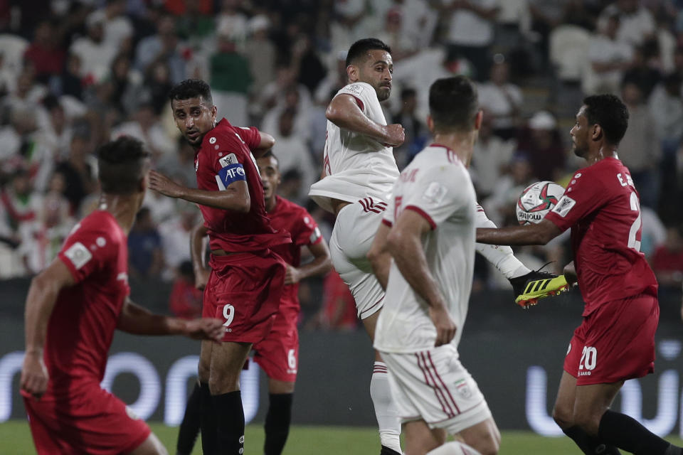 Iran's midfielder Omid Ebrahimi, center, jumps for the ball with Yemen's forward Emad Mansoor, right, during the AFC Asian Cup group D soccer match between Iran and Yemen at the Mohammed Bin Zayed Stadium in Abu Dhabi, United Arab Emirates, Monday, Jan. 7, 2019. (AP Photo/Nariman El-Mofty)