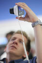 BERLIN, GERMANY - AUGUST 30: A visitor tries out the new Samsung Galaxy Camera, which combines a smartphone and a digital camera with a zoom lens, during a press day at the Samsung stand at the IFA 2012 consumer electronics trade fair on August 30, 2012 in Berlin, Germany. IFA 2012 will be open to the public from August 31 through September 5. (Photo by Sean Gallup/Getty Images)