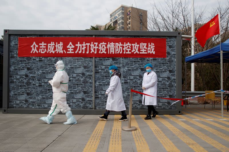 Hospital staff in protective garments walk at a checkpoint to the Hubei province exclusion zone at the Jiujiang Yangtze River Bridge in Jiujiang