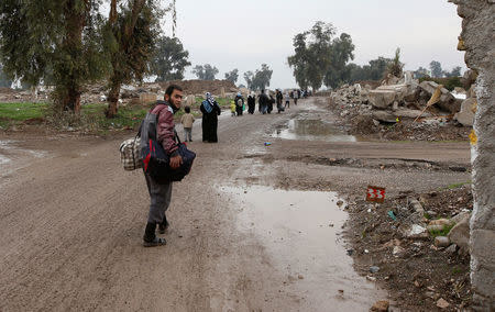 Displaced Iraqi people from the Bab al-Tob area in Mosul flee their homes after clashes to reach safe areas as Iraqi forces battle with Islamic State militants in the city of Mosul, Iraq, March 15, 2017. REUTERS/Youssef Boudlal