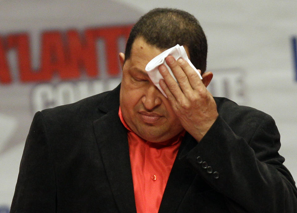 FILE - In this Thursday Feb. 23, 2012 file photo, Venezuela's President Hugo Chavez wipes his forehead as he attends a concert in his honor at the Teresa Carreno Theater in Caracas, Venezuela. Throughout his presidency, Chavez has relied on his vigor and endurance: playing baseball and speaking for hours at a stretch. Now Chavez finds himself ailing as he heads into a re-election campaign against Henrique Capriles, a 39-year-old state governor who represents a younger and more energetic option, said Diego Moya-Ocampos, an analyst with the London-based consulting firm IHS Global Insight. (AP Photo/Fernando Llano, File)