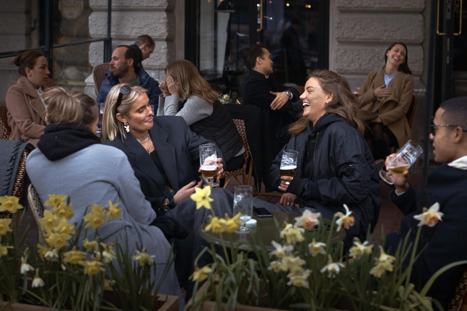 FILE - In this Wednesday, April 8, 2020 file photo people chat and drink outside a bar in Stockholm, Sweden. Sweden is pursuing relatively liberal policies to fight the coronavirus pandemic, even though there has been a sharp spike in deaths. The prime minister has proposed a new emergency law that would allow the authorities to shut down public venues and transportation quickly if needed. But for now, it's still common to see people swarming on the Stockholm waterfront, sipping cocktails, while children still have group soccer practice. (AP Photo/Andres Kudacki, File)