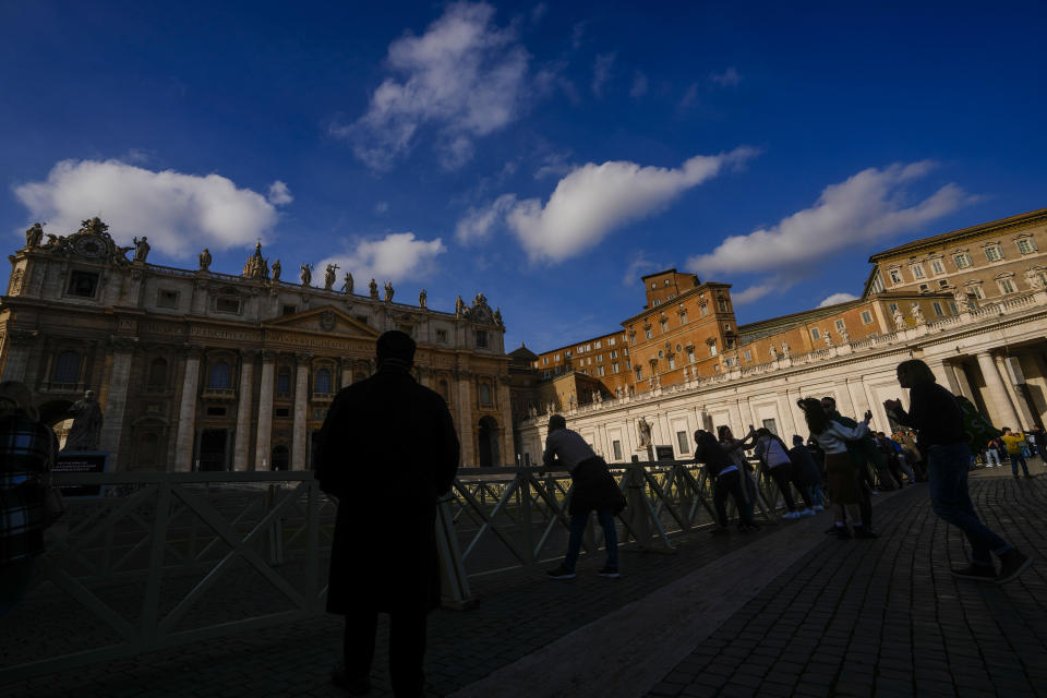 People look at St' Peter's Basilica at The Vatican, Saturday, Dec. 31, 2022. Pope Emeritus Benedict XVI, the German theologian who will be remembered as the first pope in 600 years to resign, has died, the Vatican announced Saturday. He was 95. (AP Photo/Andrew Medichini)