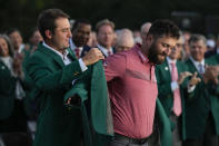 Scottie Scheffler puts the green jacket on Jon Rahm, of Spain, after Rahm won the Masters golf tournament at Augusta National Golf Club on Sunday, April 9, 2023, in Augusta, Ga. (AP Photo/Charlie Riedel)
