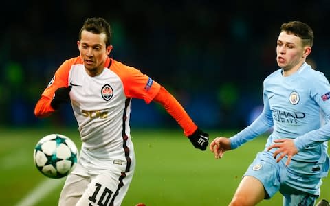 Bernard playing for Shakhtar challenges for the ball with Manchester City's Phil Foden - Credit: AP