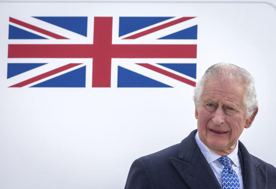 Britain's King Charles III stands in front of the plane after arriving at BER Airport in Berlin, Germany, Wednesday, March 29, 2023. (Britta Pedersen/dpa via AP)