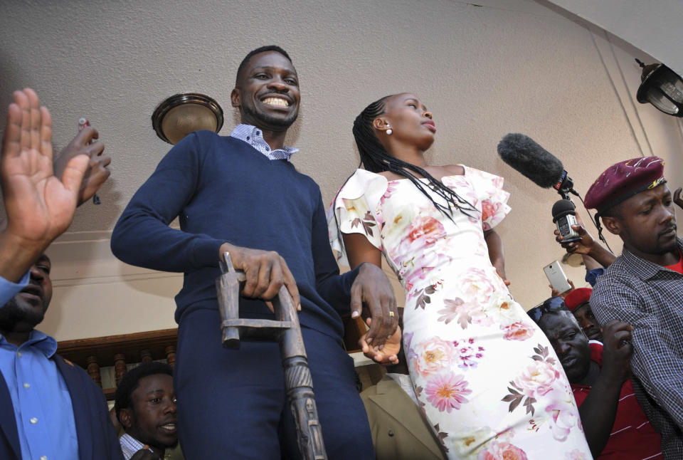 Pop star-turned-opposition lawmaker Bobi Wine, whose real name is Kyagulanyi Ssentamu, smiles to supporters accompanied by his wife Barbara Itungo Kyagulanyi at his home in Kampala, Uganda Thursday, Sept. 20, 2018. Wine vowed Thursday to continue his fight for more freedom in the country "or we shall die trying," shortly after security forces took him into custody on his arrival from the United States after treatment for alleged torture. (AP Photo/Ronald Kabuubi)