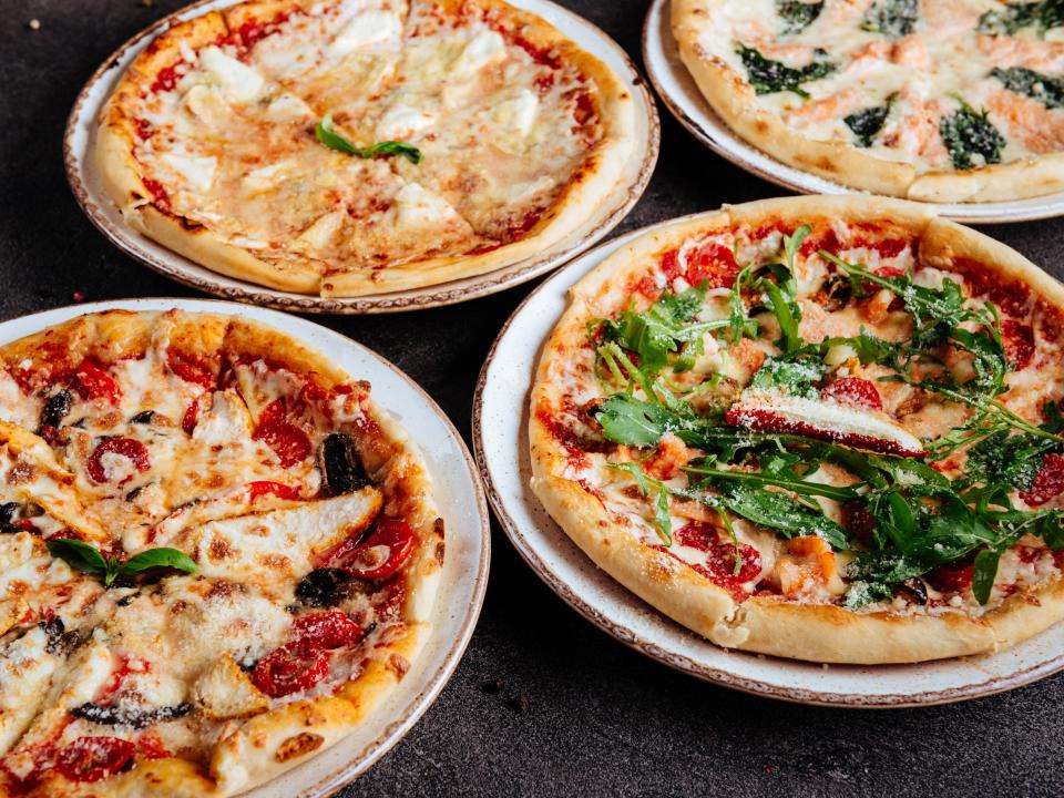 Four small pizzas with different toppings on each one.