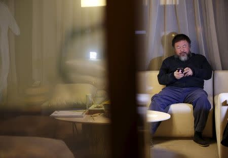 Dissedent Chinese artist Ai Weiwei uses his mobile phone at an interview with Reuters at the hotel he is staying at in Beijing, March 24, 2015. REUTERS/Kim Kyung-Hoon