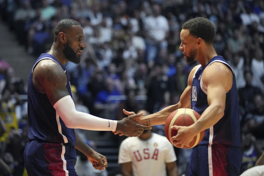 United States’ forward LeBron James, left, and United States’ guard Stephen Curry shake hands during an exhibition basketball game between the United States and South Sudan, at the o2 Arena in London, Saturday, July 20, 2024. (AP Photo/Kin Cheung)<span class="credit"> – </span>