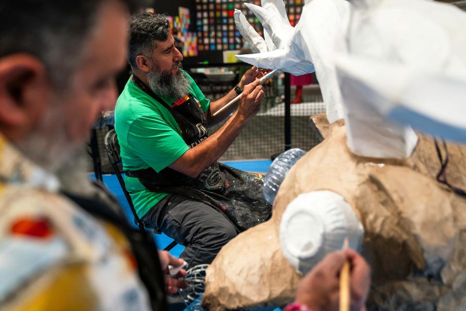 Artists Oscar Becerra Mora, front, and Ruben Mica work on an alebrije sculpture Friday at Fort Collins Museum of Discovery.