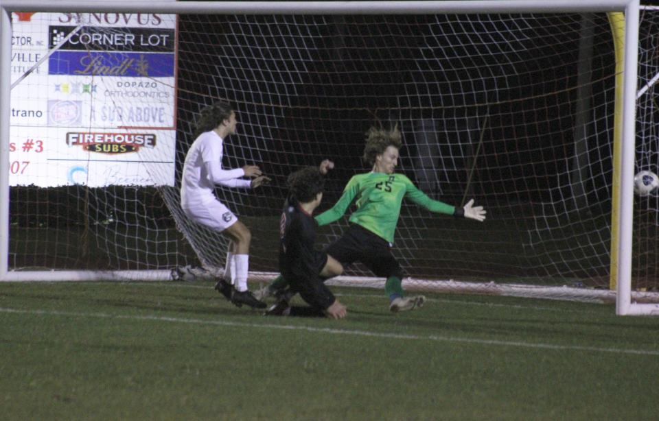 Bishop Kenny's Joseph Jimenez (8) lunges to score the go-ahead goal as Beachside's Landon Liotta (16) and goalkeeper Owen Carey (25) defend during an FHSAA Region 1-4A boys soccer semifinal on February 13, 2023. [Clayton Freeman/Florida Times-Union]