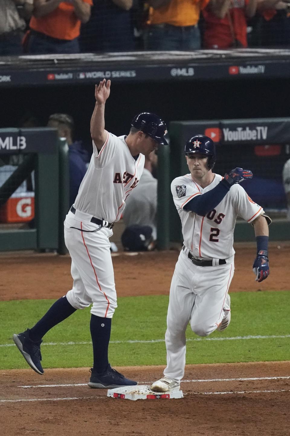 Houston Astros' Alex Bregman is congratulated by first base coach Don Kelly after hitting a two-run home run during the first inning of Game 2 of the baseball World Series against the Washington Nationals Wednesday, Oct. 23, 2019, in Houston. (AP Photo/Eric Gay)