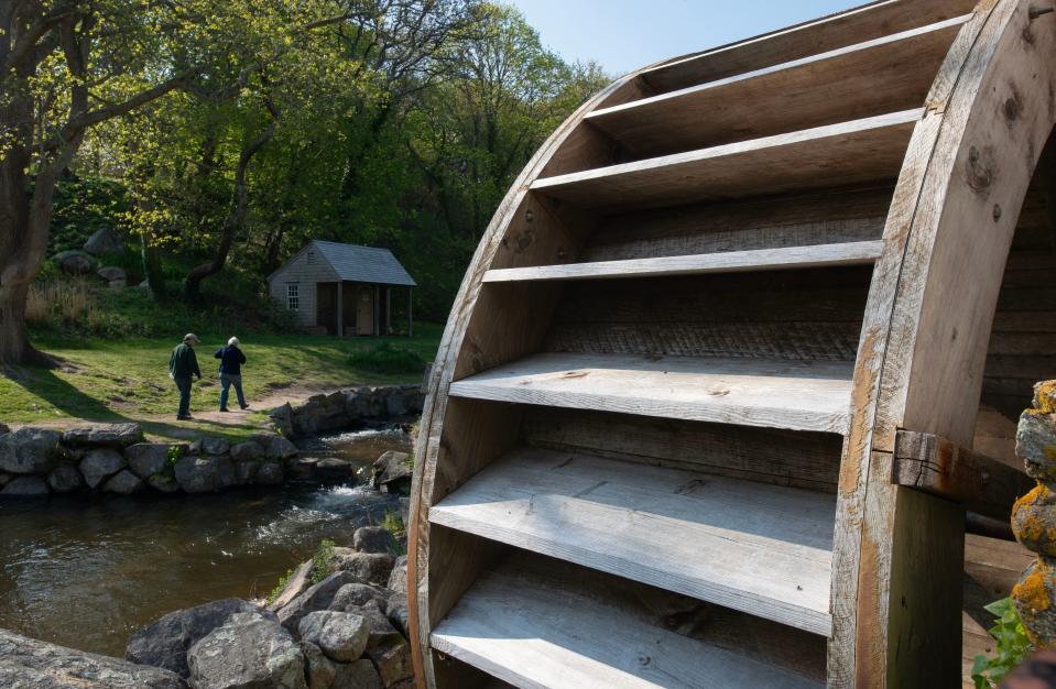 A renovated mill wheel frames morning walkers on May 14 around the mill pond at Stony Brook Grist Mill and Museum grounds in Brewster.