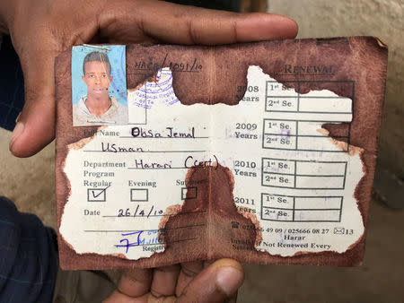 Abedir Jamal holds the identification card of his late brother Obsa Jemal, who was killed in anti-government protests, during a Reuters interview in Harar, Ethiopia July 22, 2018. REUTERS/Maggie Fick