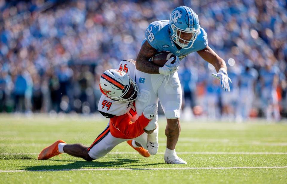 Campbell’s Ed Dennis (44) works to slow North Carolina’s Omarion Hampton (28) as he romps ten yards to set up a touchdown, giving the Tar Heels’ a 28-7 lead over Campbell in the second quarter on Saturday, November 4. 2023 at Kenan Stadium in Chapel Hill, N.C.