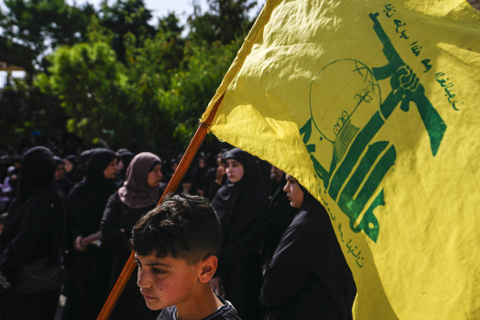People attend the funeral procession of Hezbollah fighter, Bilal Nemr Rmeiti, who was killed by Israeli shelling, during his funeral procession in Majadel village, south Lebanon, Sunday, Oct. 22, 2023. (AP Photo/Hassan Ammar)