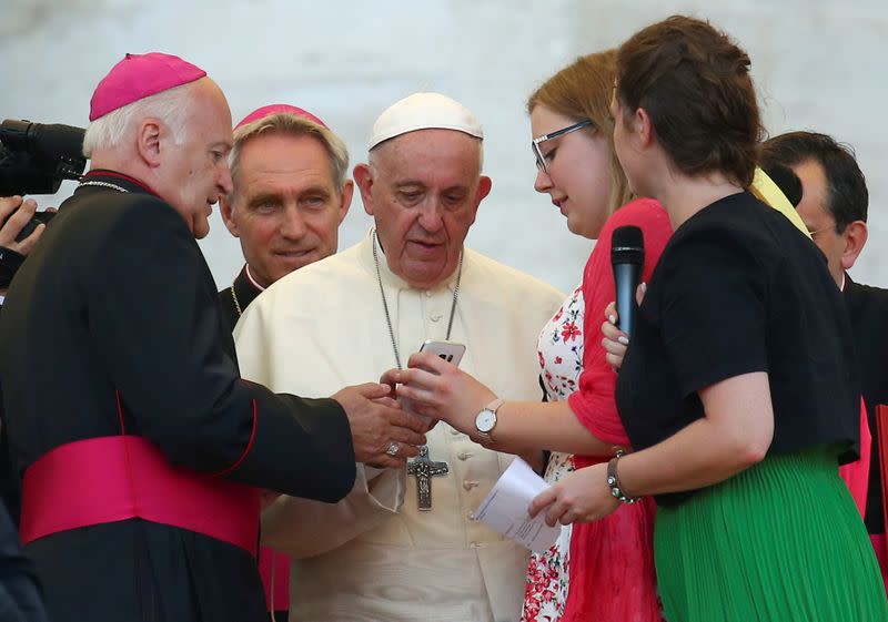 FILE PHOTO: Pope Francis sends a message on a mobile phone at the end of a special audience with altar servers in Saint Peter's square at the Vatican