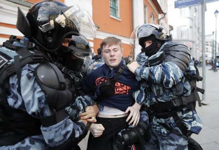 Law enforcement officers detain a man after a rally to demand authorities allow opposition candidates to run in a local election in Moscow