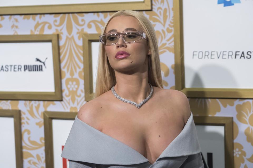 Iggy Azalea wears tinted glasses and an off-shoulder dress