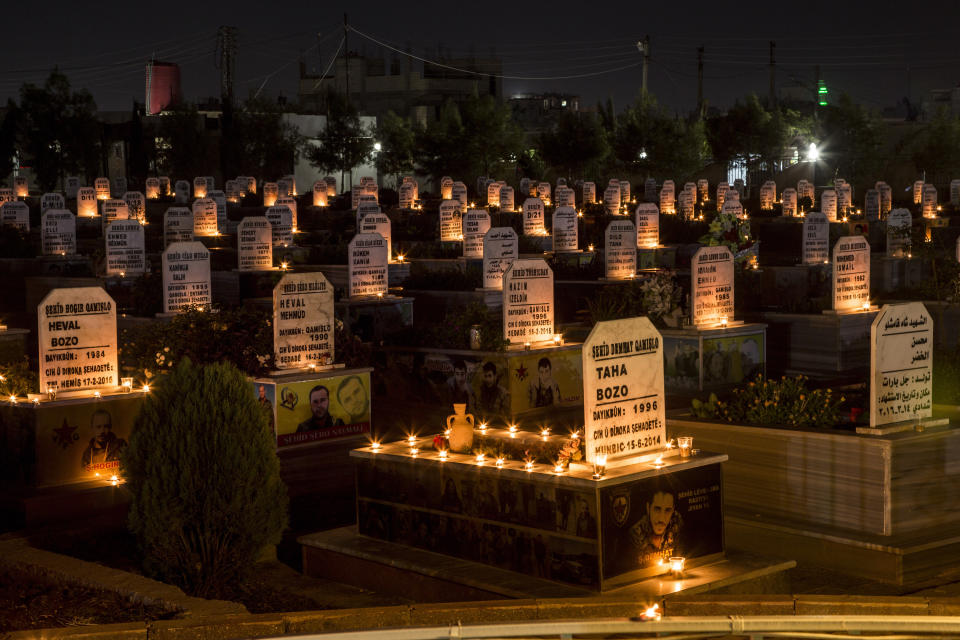 Candles are lit on the graves of people killed during Syrian war, in the town of Qamishli, north Syria, Thursday, Oct. 31, 2019. (AP Photo/Baderkhan Ahmad)
