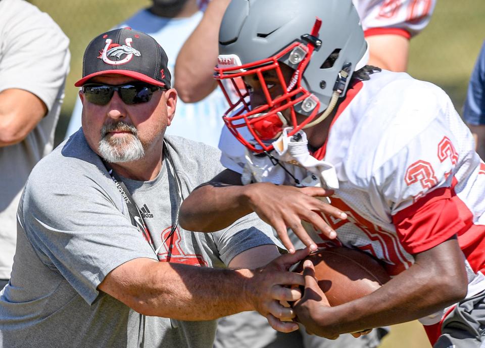 Palmetto High Head Coach Doug Shaw hands off to running back DJ Watt during a drill during Spring football practice in Williamston, S.C. Tuesday, May 17, 2022.  