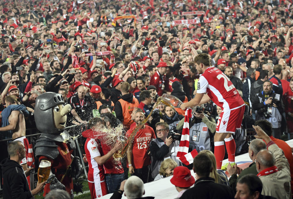 Christopher Lenz of FC Union Berlin celebrates with fans after the soccer match with VfB Stuttgart in Berlin, Germany, Monday May 27, 2019. FC Union Berlin secured promotion to the Bundesliga. (Joerg Carstensen/dpa via AP)