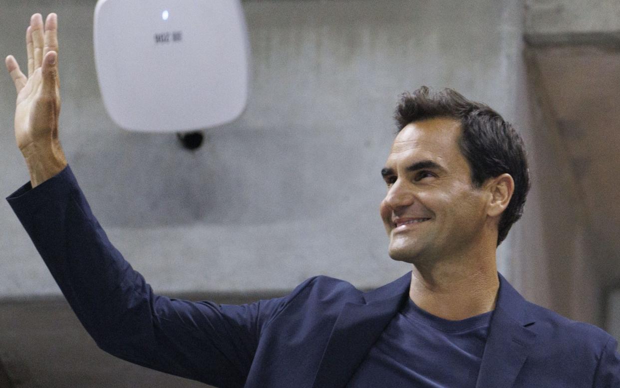 Roger Federer waves to the crowd during a break in the match between Qinwen Zhang and Aryna Sabalenka during their quarter-final in the US Open