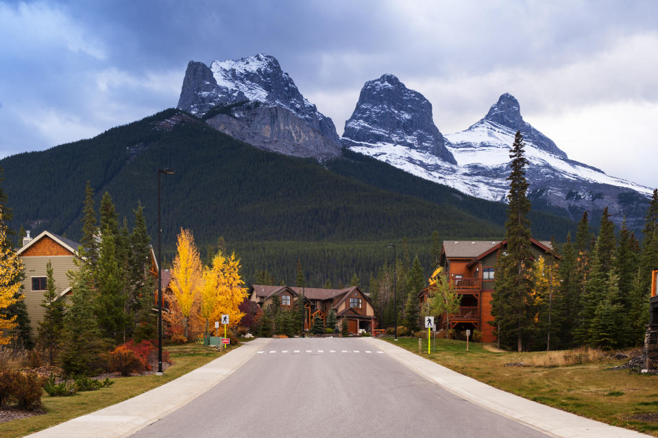 A road leading to a mountain village with twin peaks in the background