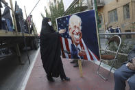 A demonstrator carries a banner with a caricature of the U.S. President Joe Biden in a rally in front of the former U.S. Embassy commemorating the anniversary of its 1979 seizure in Tehran, Iran, Thursday, Nov. 4, 2021. The embassy takeover triggered a 444-day hostage crisis and break in diplomatic relations that continues to this day. (AP Photo/Vahid Salemi)