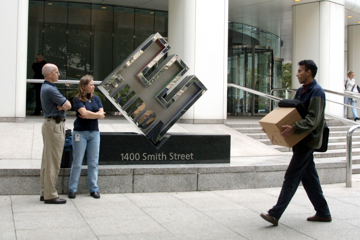 Enron employees leave the company's headquarters after being laid off 