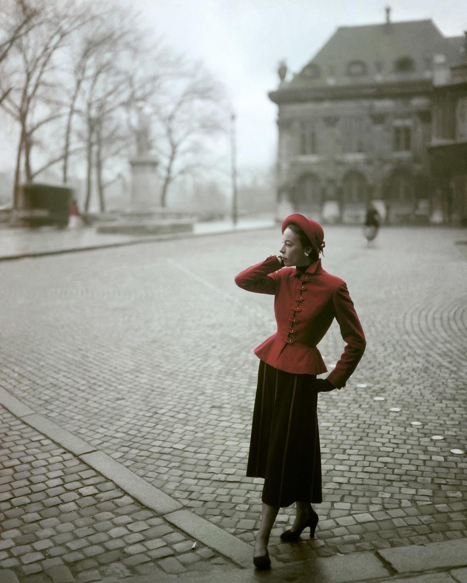 “For the First Time Original Models from the Paris Collections. By Balmain: Vogue Pattern No. 1054. Here, one of the liveliest suit-dresses of the collection: a scarlet wool jacket-top, tab-buttoned, snug-waisted; a black wool skirt with scarlet insets. The top angles out over the skirt.”