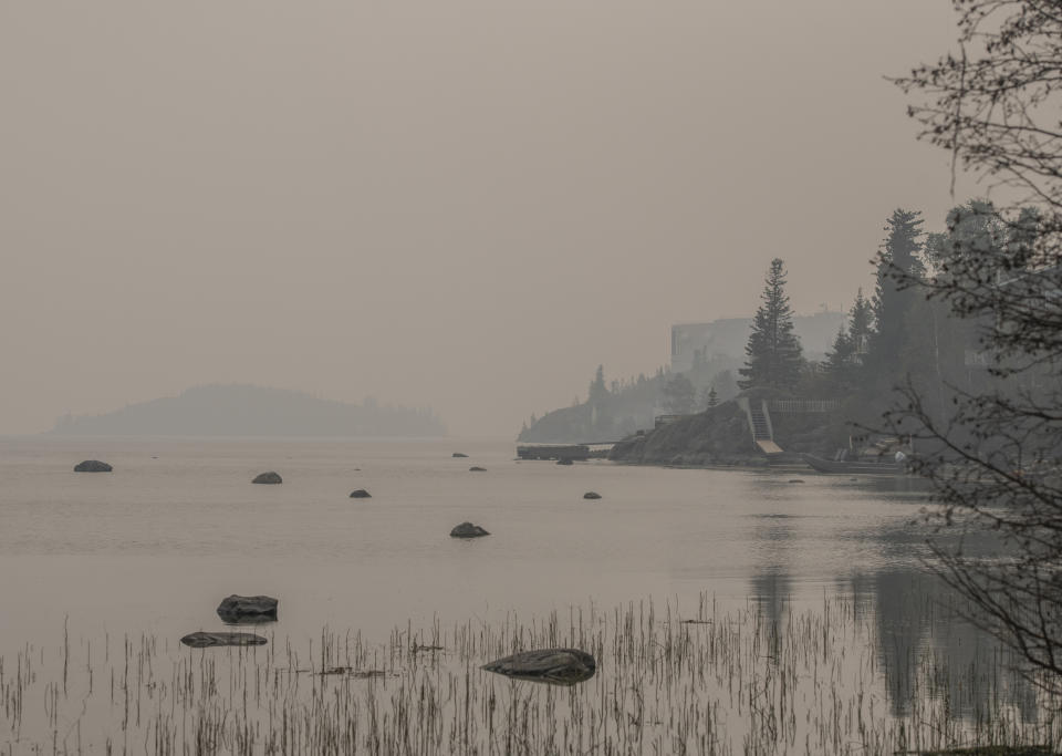 Heavy smoke from nearby wildfires fills the sky along the shoreline on Yellowknife Bay in Yellowknife on Tuesday, August 15, 2023. THE CANADIAN PRESS/Angela Gzowski
