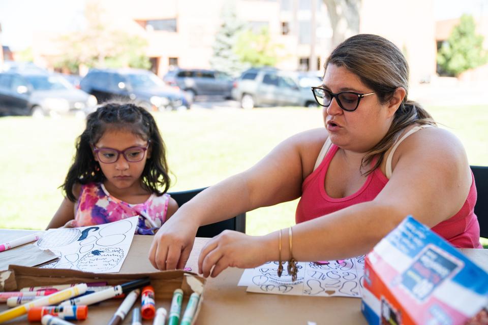 Sable Madrid and her daughter Bella make a paper puppet at a local fair in Greeley.