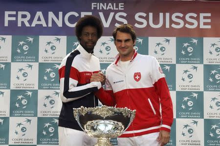Switzerland's Roger Federer (R) shakes hands with France's Gael Monfils during the draw for the Davis Cup final in Lille, northern France, November 20, 2014. REUTERS/Pascal Rossignol