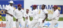 West Indies team members congratulate Kyle Mayers, second left, for taking a run out to dismiss Sri Lankan captain Dimuth Karunaratne during the day three of their second test cricket match in Galle, Sri Lanka, Wednesday, Dec. 1, 2021. (AP Photo/Eranga Jayawardena)